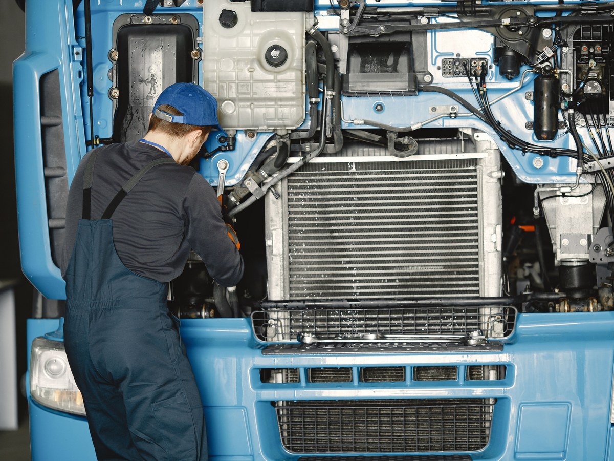 Technician servicing a lorry engine bay