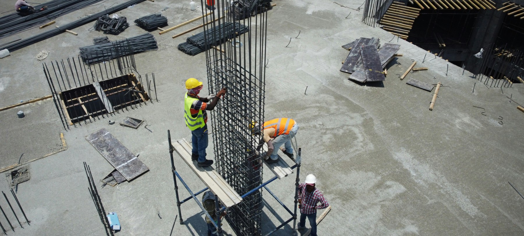 Steel fixers tying a column on a concrete deck