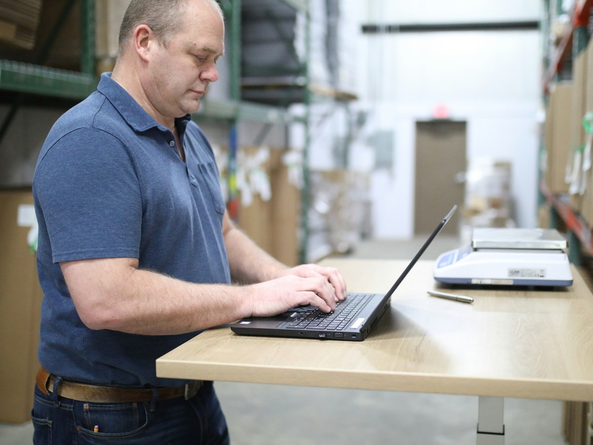 Owner working at a standing desk in a warehouse
