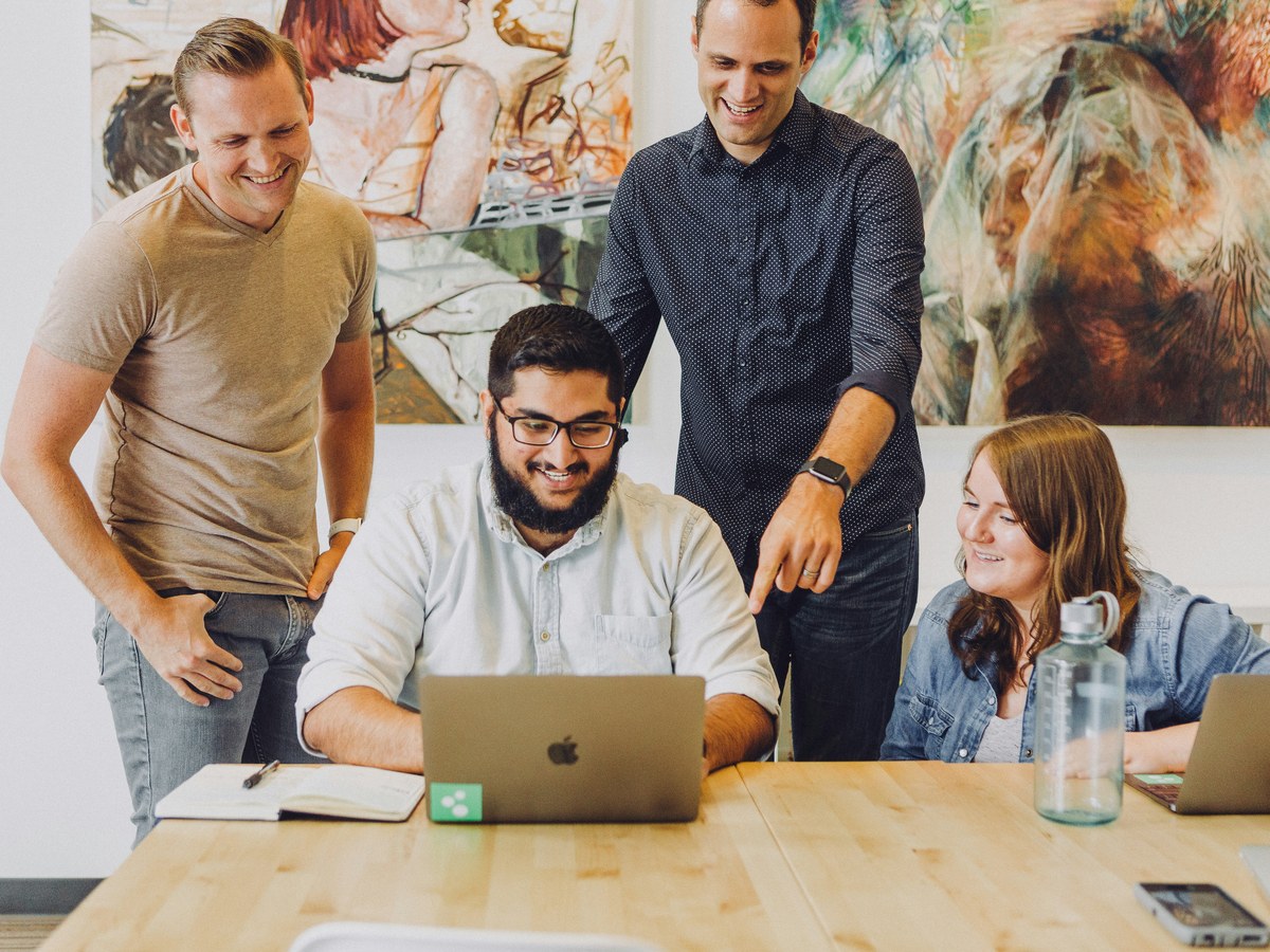 Team gathered around a laptop in an office