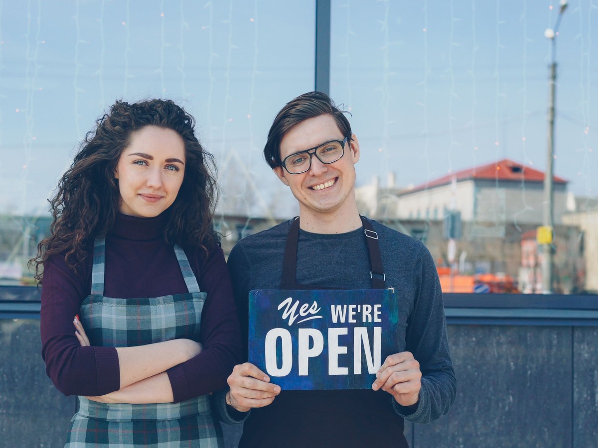 Owners with an open sign outside their premises