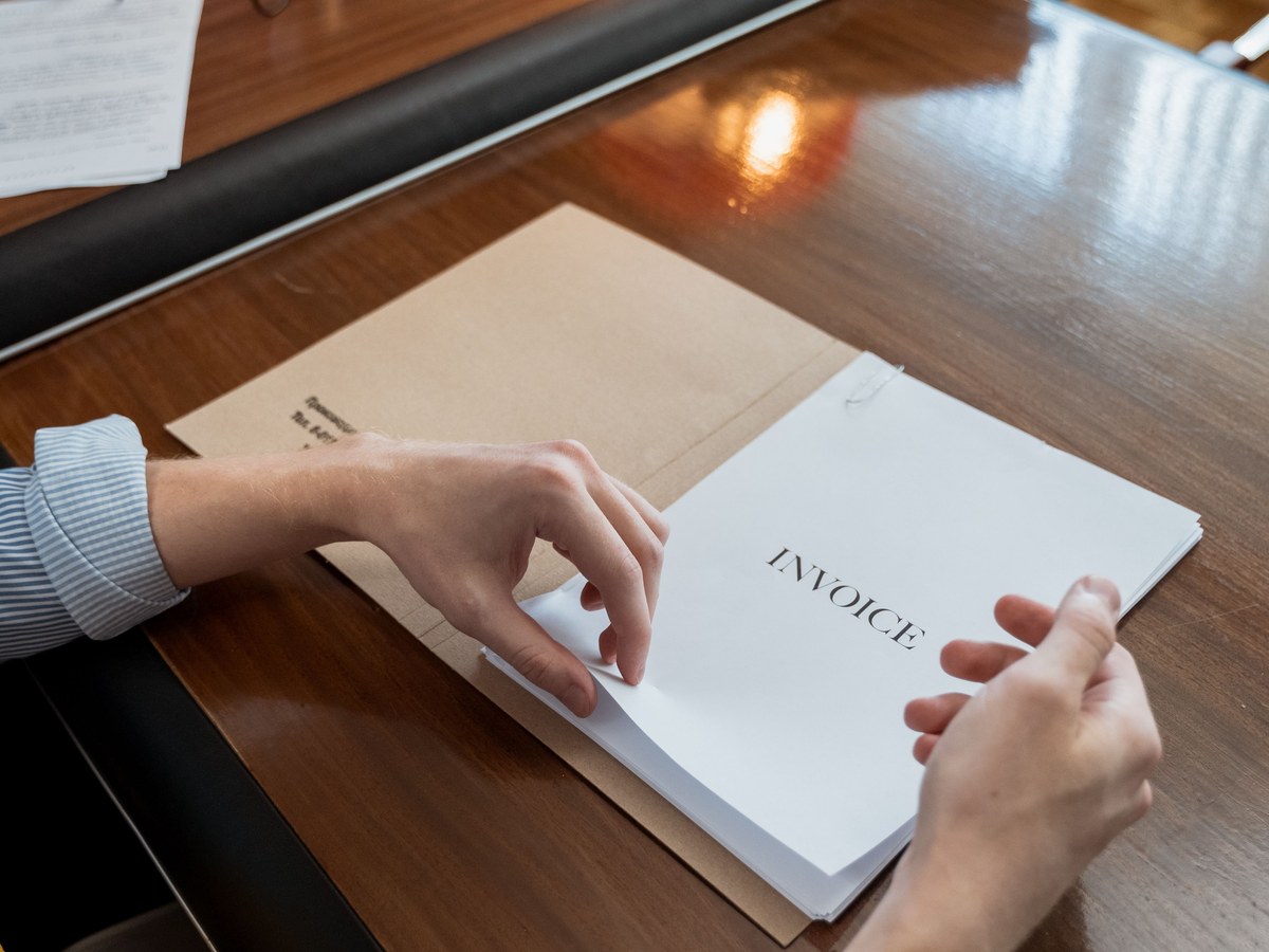 Invoice being handed across a desk