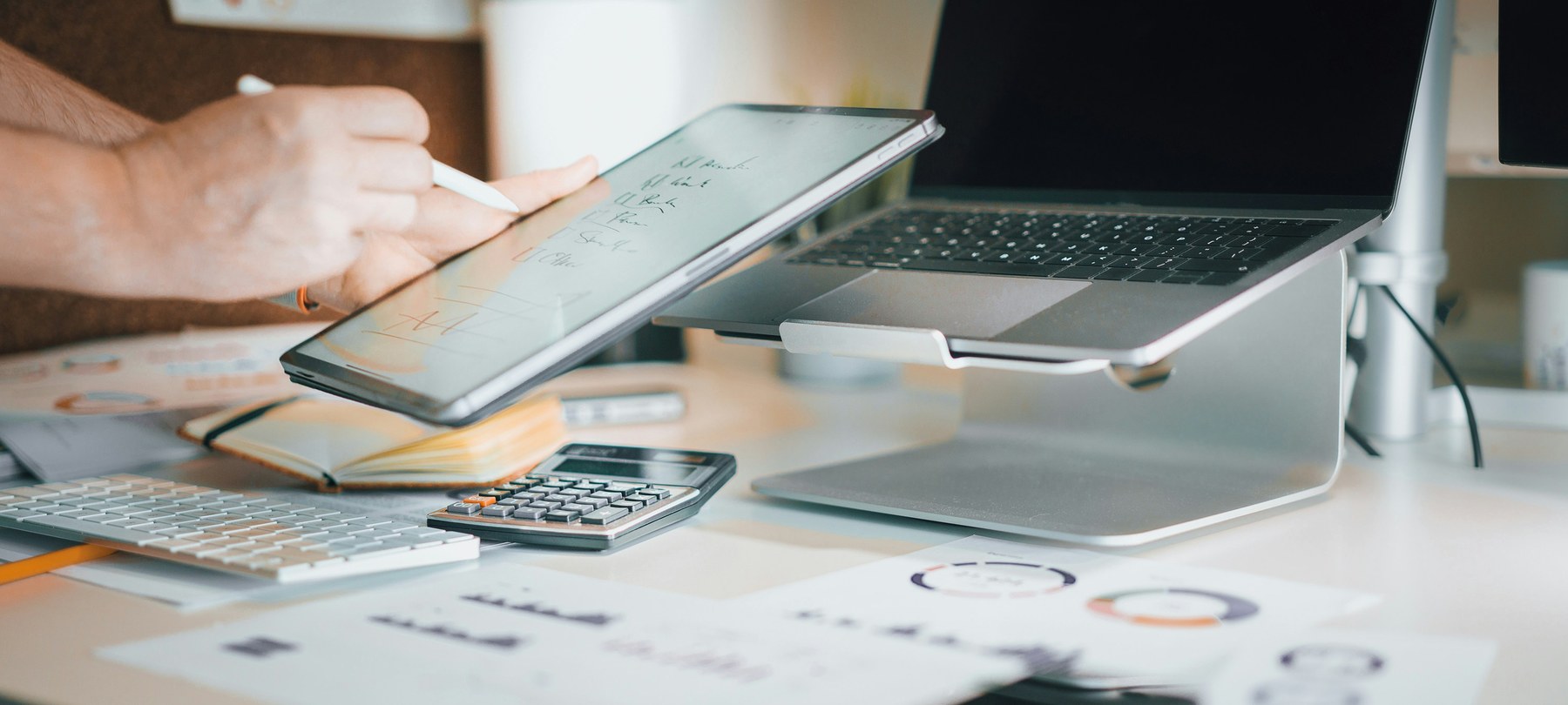 Working through figures at a desk with reports and a calculator