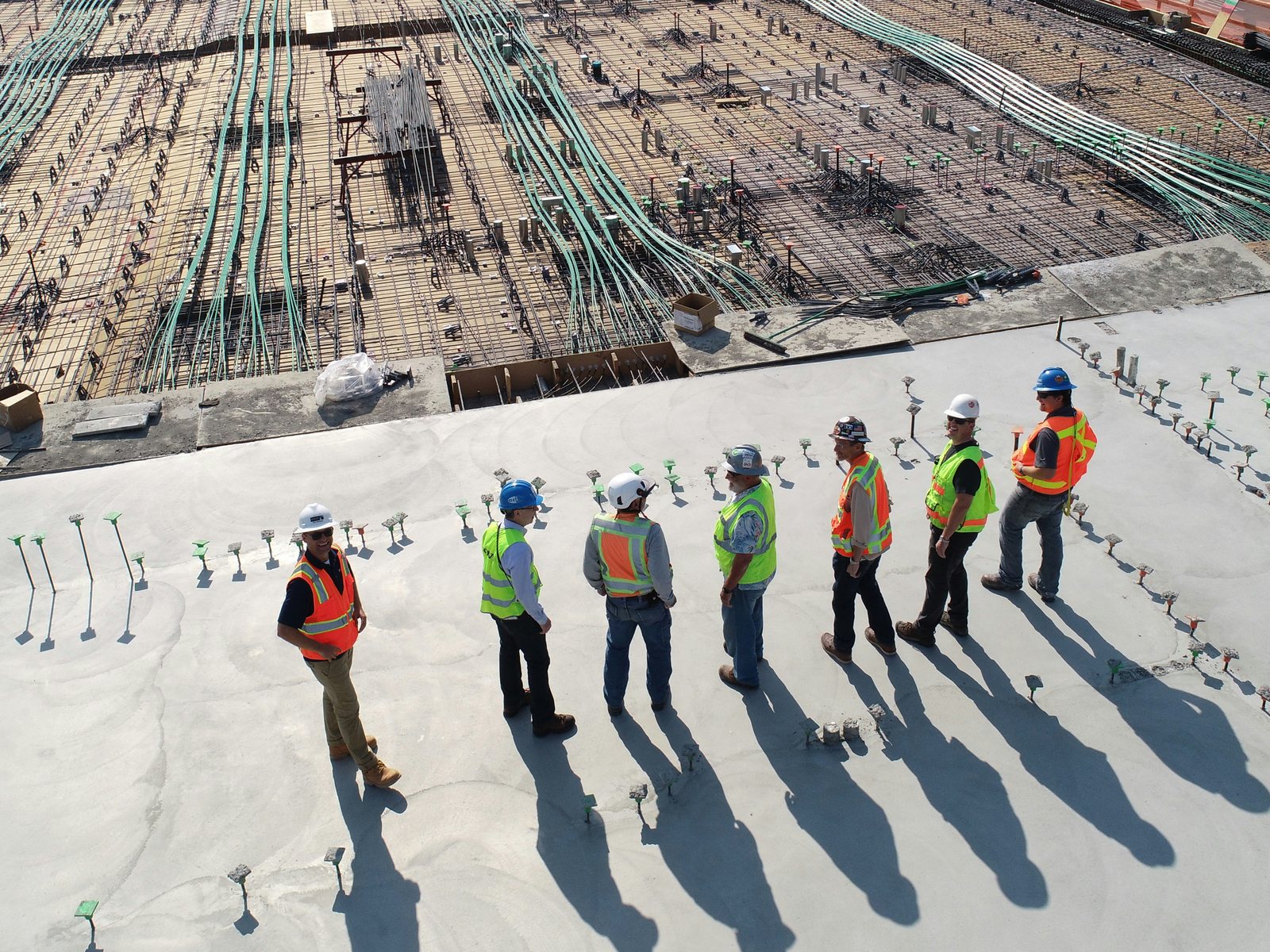 Site crew on a poured deck beside a reinforced slab