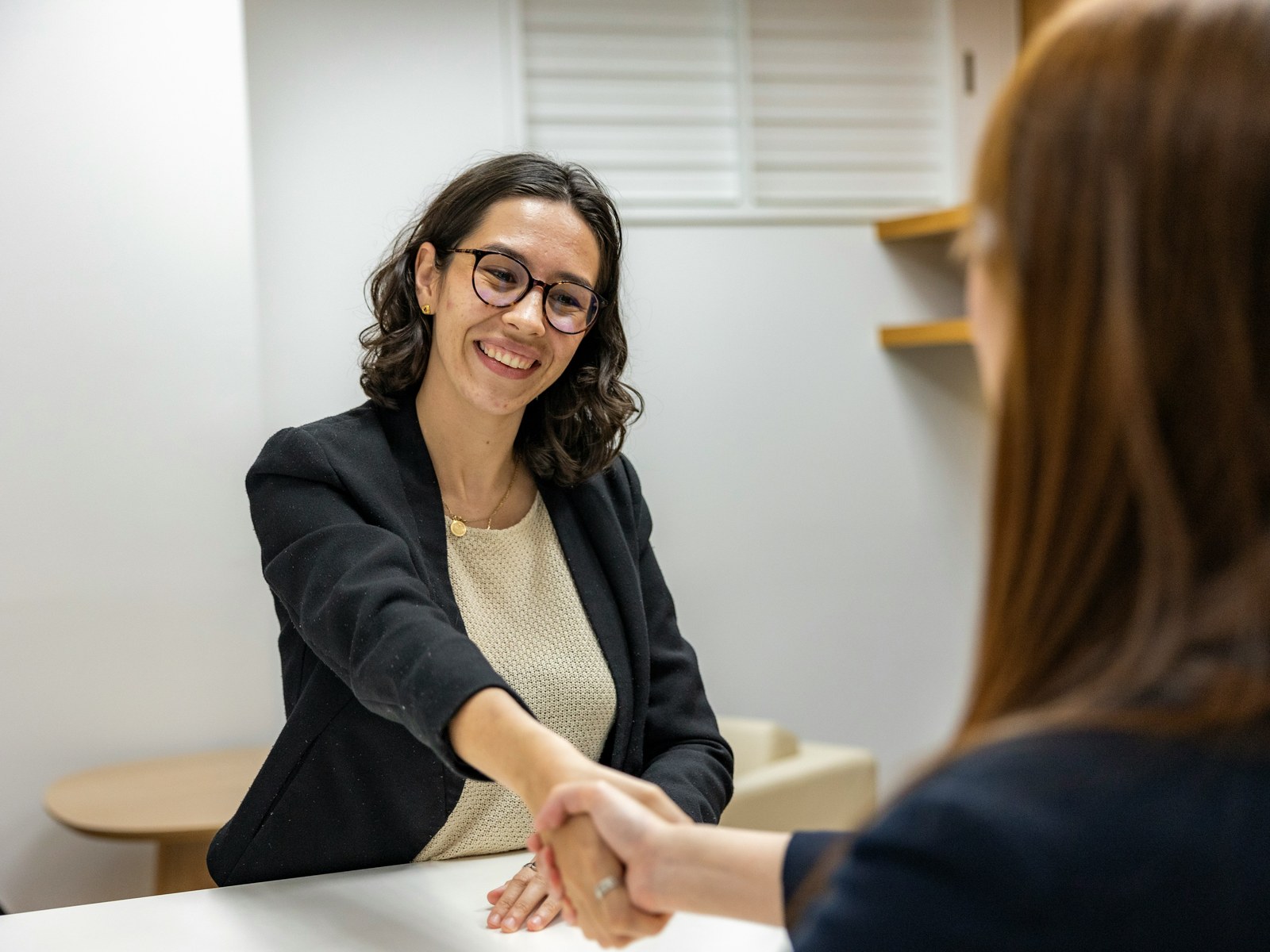 Recruiter greeting a candidate across an interview desk